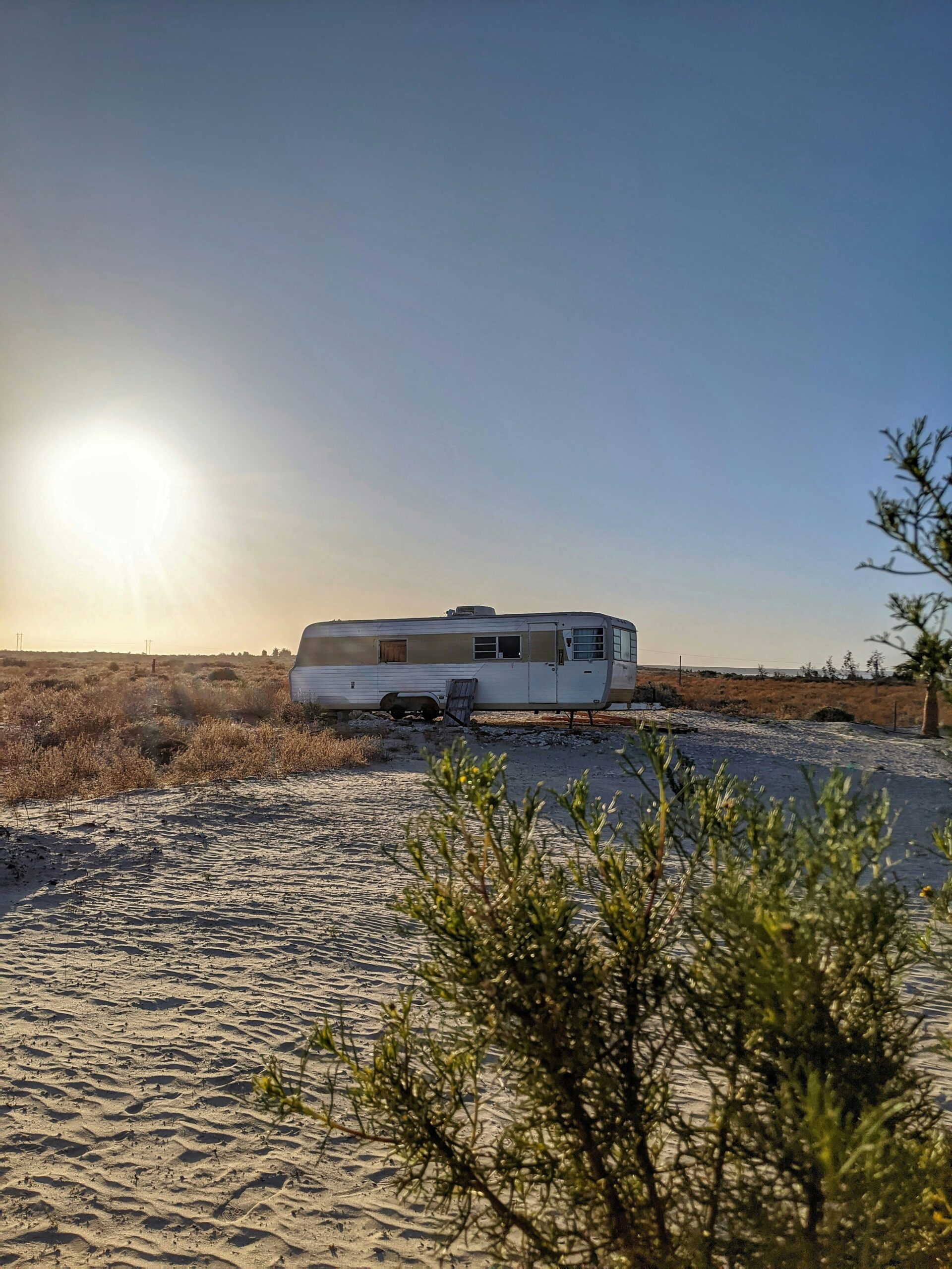 white rv trailer on brown field during daytime