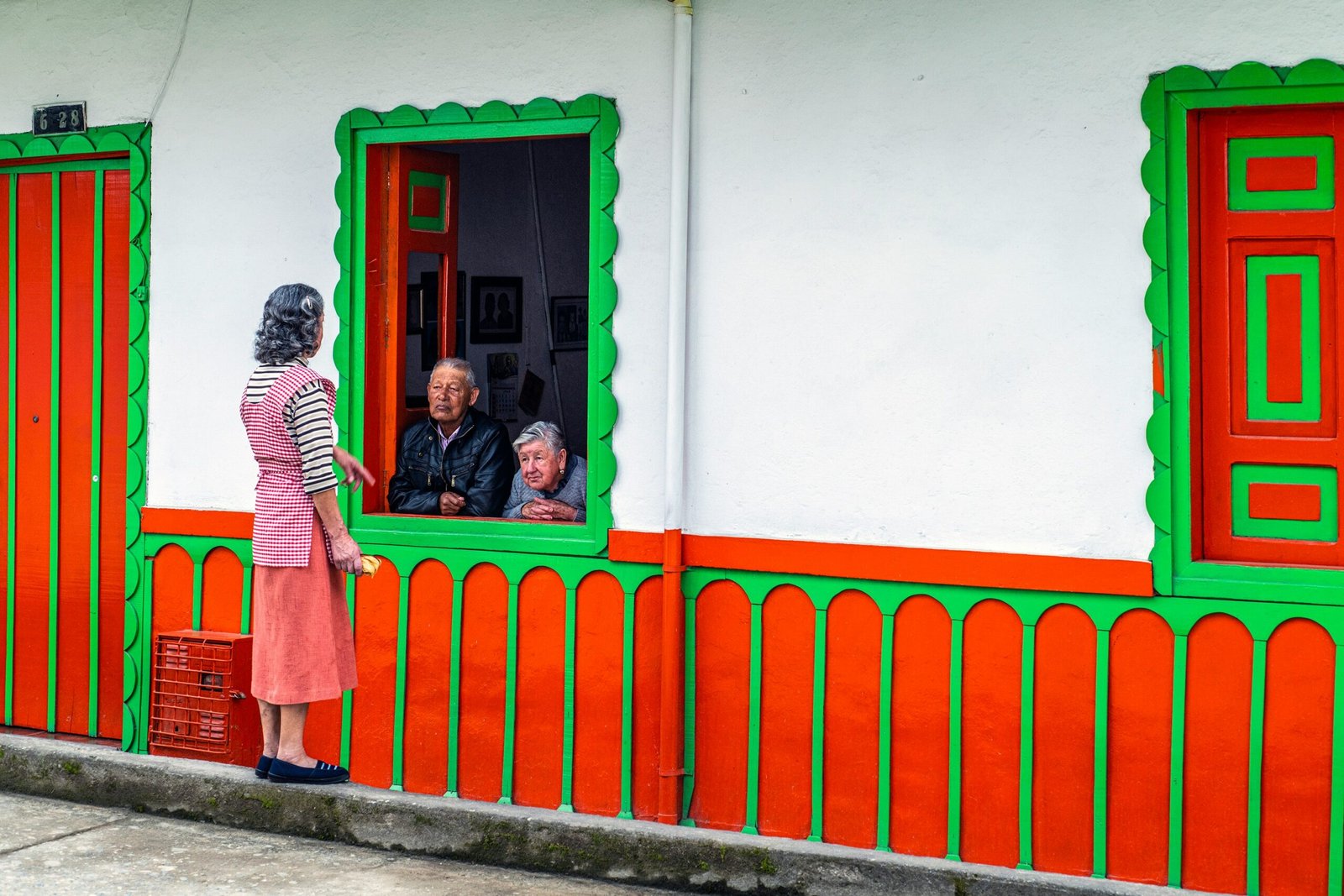 A woman standing outside of a colorful building